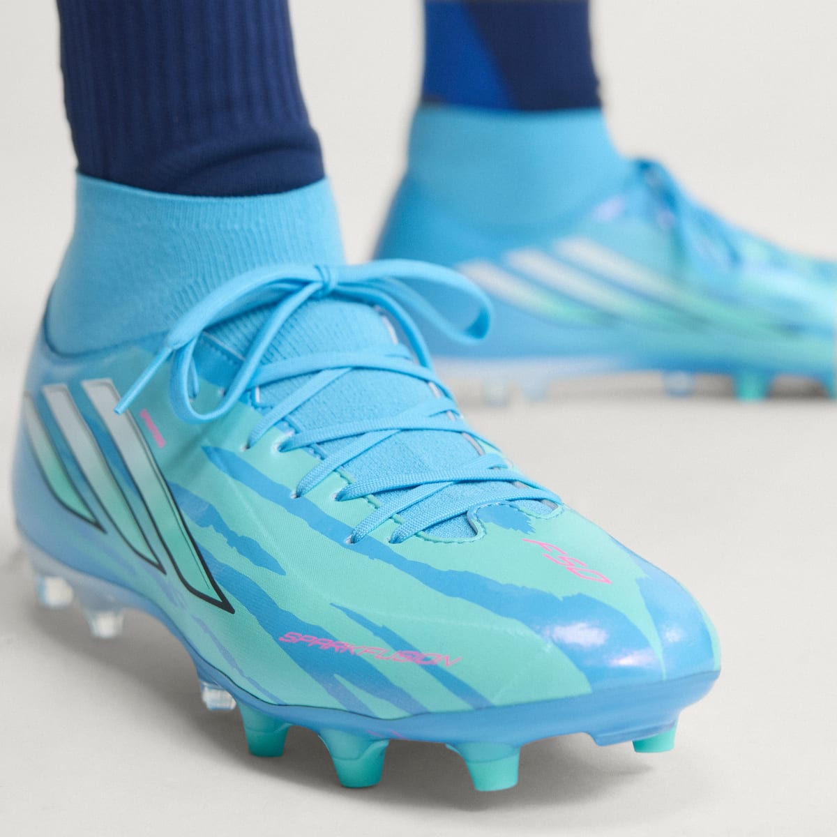 adidas Women's F50 Sparkfusion League Mid Cut Firm Ground / Artificial Grass Soccer Cleats Trinity Rodman - Semi Blue Burst / Cloud White / Lucid Pink